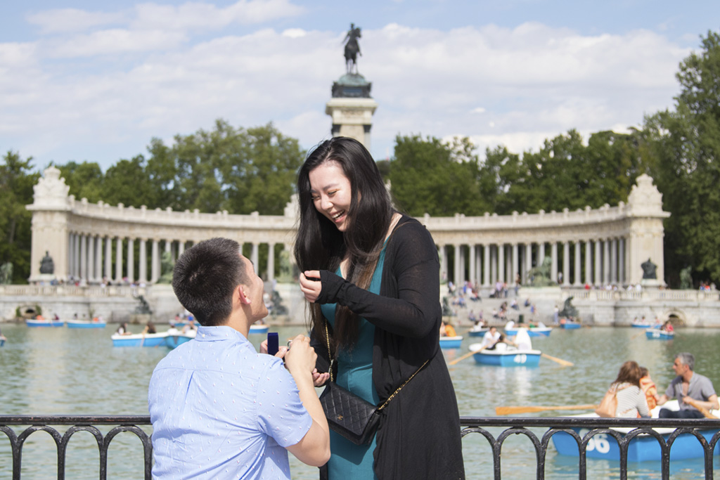 A couple declaring their love in Madrid, Spain, in front of iconic landmarks.